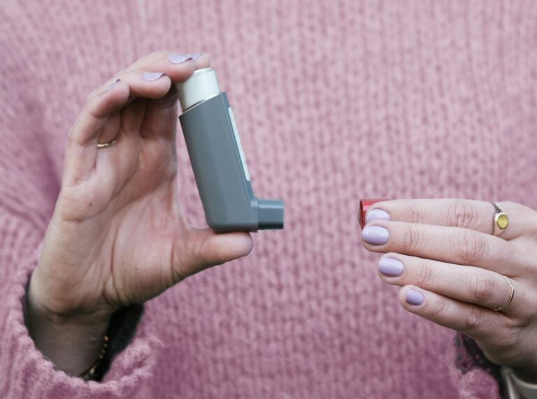 Mano sosteniendo un inhalador para el asma
