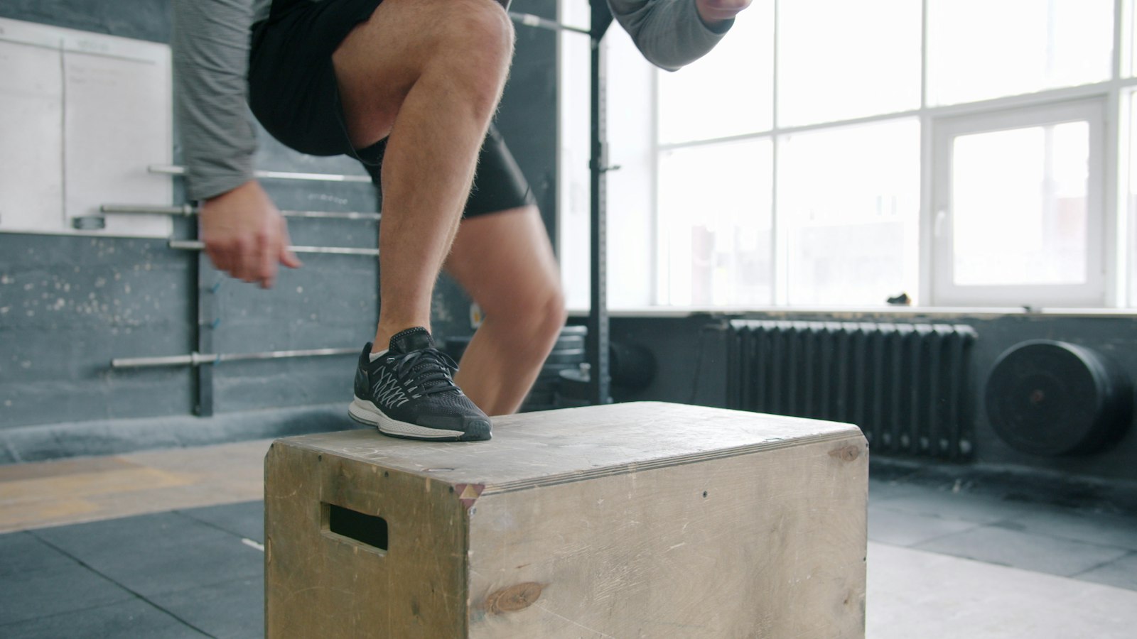 Deportista saltando al cajón en un gimnasio